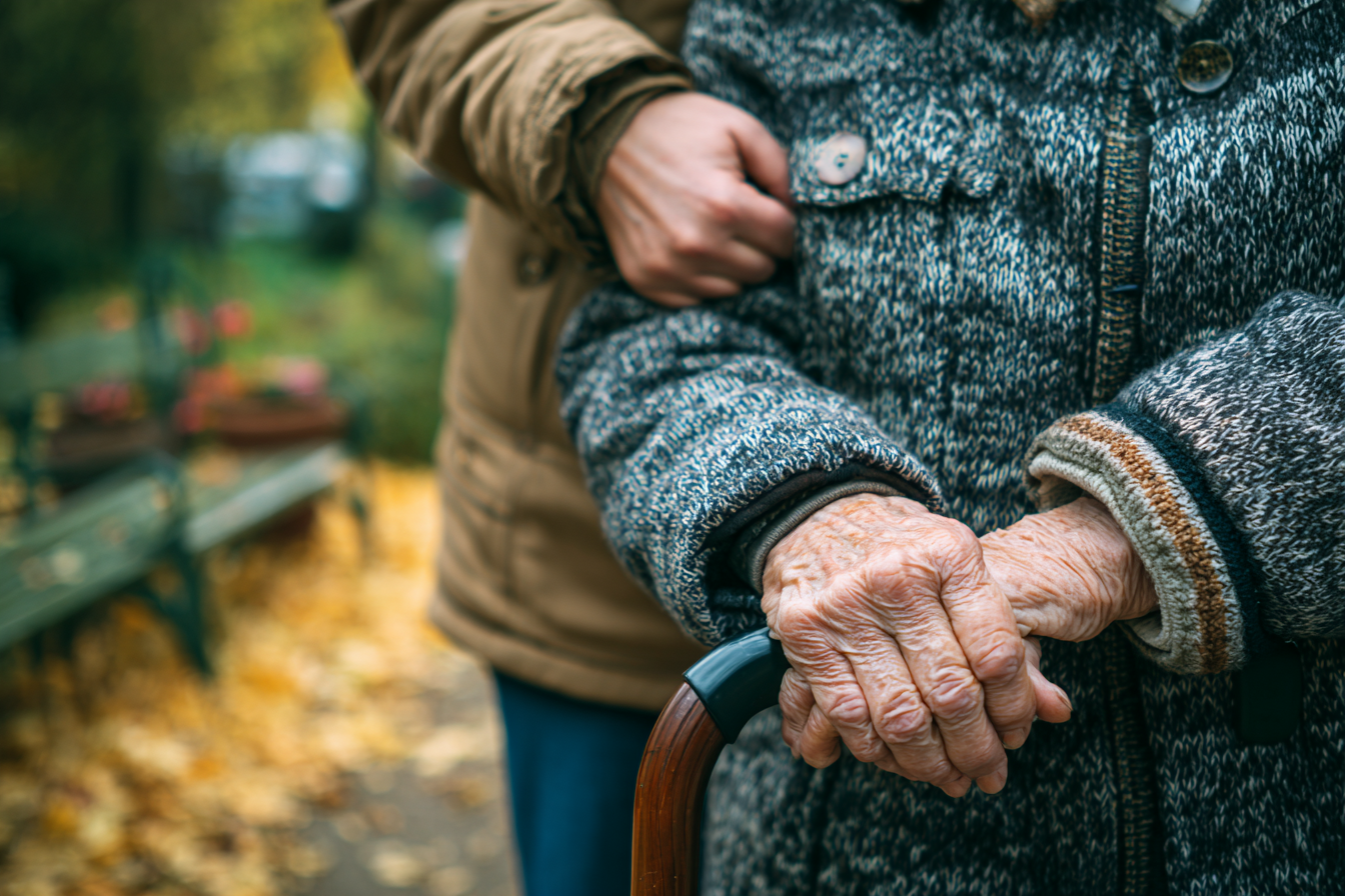 Home care caregiver stabilizing an elderly patient with Parkinson's Disease
